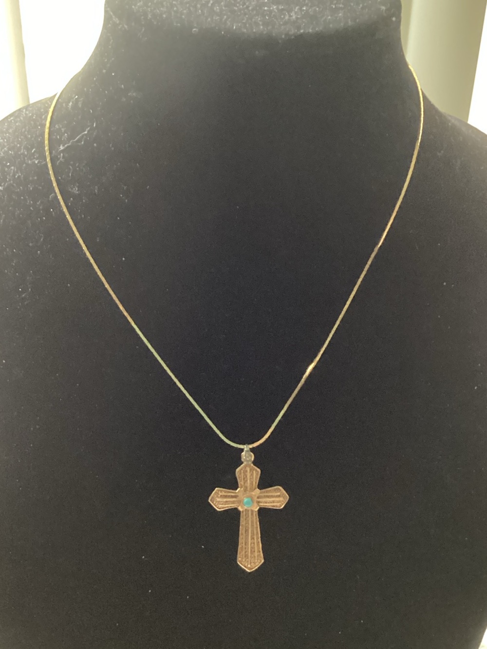 Lovely Goldtone tone cross with turquoise stone in center hanging from gold chai